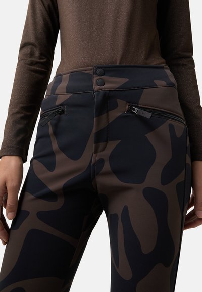 High-waisted black and brown patterned pants with a smooth texture, featuring two zippered pockets and button closures at the waist.