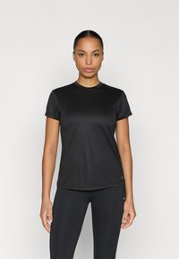 Schwarzes Sport-T-Shirt mit kurzen Ärmeln, rundem Ausschnitt und glatter Textur, kombiniert mit schwarzen Leggings. Schlichtes Design mit minimalen Details.