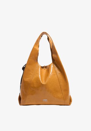 Sac fourre-tout en cuir jaune avec une texture douce et brillante, doté d'une poignée courbée et d'un logo de marque bien visible en bas.