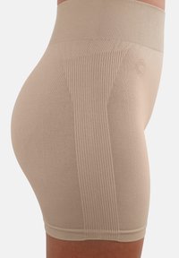 Beige Formshorts mit glatter Textur, breitem Bund und gerippten seitlichen Einsätzen für Unterstützung. Keine sichtbaren Nähte oder Logos.