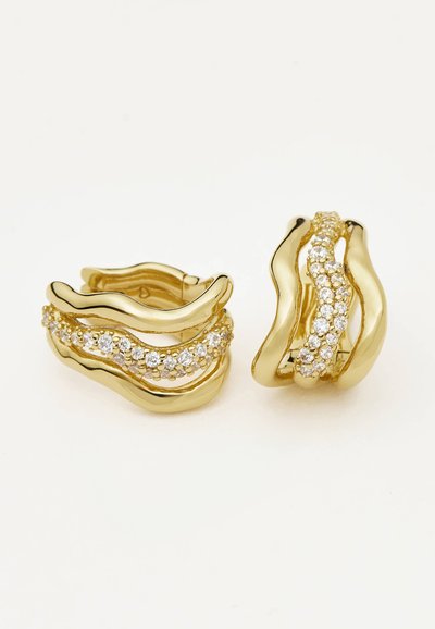 Ζευγάρι χρυσών κρίκων με κυματιστές σχεδιαστικές λεπτομέρειες και ενσωματωμένα μικρά διάφανα κρύσταλλα στη μεσαία σειρά, σε λευκό φόντο.