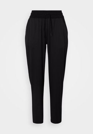 Mustad lõdva lõikega püksid elastse vöökohaga, nöörpaeltega ja küljetaskutega, esitatud valgel taustal.