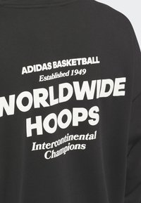 Black shirt with white text: "Adidas Basketball Established 1949 Worldwide Hoops Intercontinental Champions."