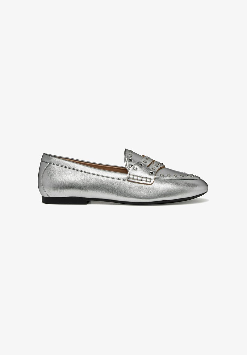 Mocassin en cuir argenté à texture douce, avec des accents cloutés sur l'avant et une semelle noire plate, conçu pour un usage décontracté.