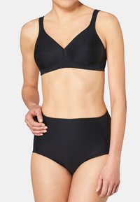 Soutien-gorge en coton noir avec un design en V, texture côtelée, larges bretelles et une bande sous poitrine, accompagné d'une culotte noire taille haute.