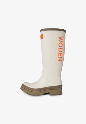 Witte rubberen regenlaars met oranje "WODEN" logo, bruine afwerking, gestructureerde zool en een gebogen vorm voor comfort.