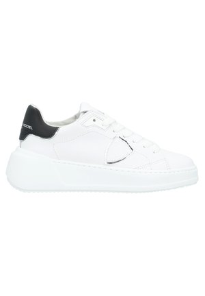 Witte leren sneaker met een zwarte hielaccent, voorzien van een textuur overlay en een platte zool. Veters en gestikte details zijn zichtbaar.