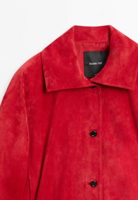 Červená semišová bunda s černými knoflíky a širokým límcem, značená Massimo Dutti.