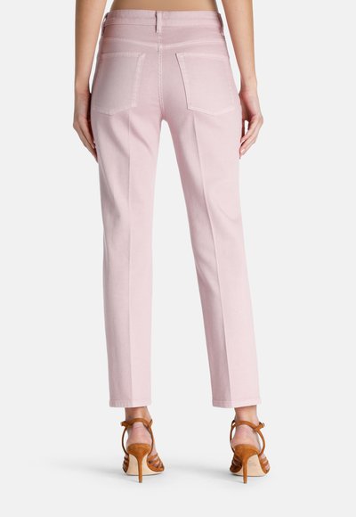 Pantalones de mezclilla rosa con corte recto, que cuentan con bolsillos traseros y una cintura alta. Combinados con sandalias de tacón marrones. Textura suave.