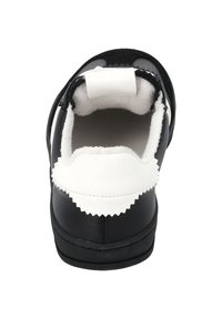 Black and white shoe with a rounded shape. Soft interior lining, textured leather exterior, and contrasting zigzag detailing on the heel.