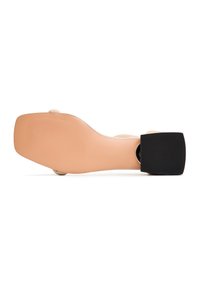 Base di scarpa nuda con tacco alto dalla forma liscia e curvata. Presenta un tacco spesso nero e un accento circolare argentato vicino al tacco. Suola con texture.