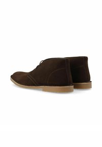 Botas chukka de ante marrón con un acabado suave. Presentan una puntera redonda, costuras sencillas y una suela de goma marrón claro. Cierre con cordones.