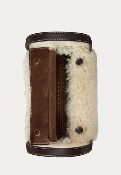 Ruskea nahkainen käsilaukku, jossa on kermanvärinen karvavuori, sileä pinta, minimalistinen muotoilu ja kaksi ylhäällä olevaa napillista sulkua.