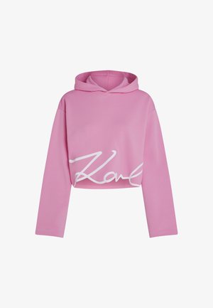 Rozā īsā kapuce izgatavota no mīksta auduma, ar garām piedurknēm un baltu drukātu parakstu logo uz priekšpuses.