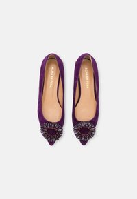 Ballet flats en suédine violette à bouts pointus, ornées d'un bijou décoratif à l'avant, avec une semelle intérieure beige portant la marque 'ALMA EN PENA'.