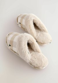 Beige and white checkered slippers with small green tree patterns, featuring fluffy cream-colored lining and insoles, placed side by side on a white surface.