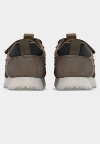 Ζευγάρι καφέ και μπεζ αθλητικά παπούτσια με λευκές σόλες, ορατά από πίσω, με ταινίες για εύκολο φόρεμα και μαύρες λεπτομέρειες στη φτέρνα.