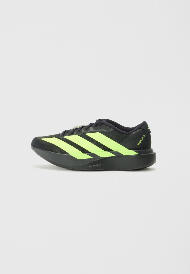 Zwarte sportieve schoen met neon groene strepen, synthetisch bovenwerk, ronde neus, lichtgewicht ontwerp en gevoerde zool. Bevat "LIGHTSTRIKE PRO" branding.