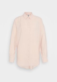 Camicia di lino rosa chiaro con maniche lunghe, chiusura frontale con bottoni, colletto strutturato e orlo leggermente curvo. Tessuto morbido con una vestibilità rilassata.