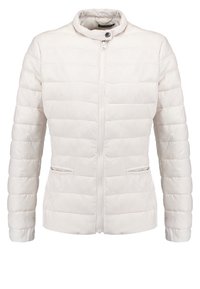 Vit quiltad jacka med blixtlås framtill, uppstående krage med tryckknapp och två sidofickor med blixtlås.
