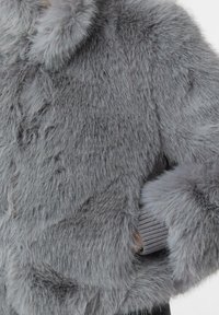 Szara kurtka z sztucznego futra z okrągłym kołnierzem, puszystą teksturą i ściągaczami z dzianiny, prezentująca różne długości włosów i połysk.