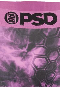 Gros plan sur une ceinture rose et noire avec le logo "PSD" au-dessus d'un tissu à motif hexagonal violet et noir avec effet fumé.