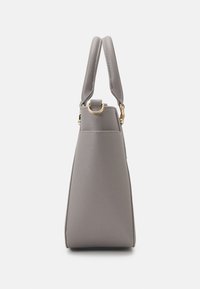 Sac à main structuré gris avec surface texturée, deux poignées et anneaux métalliques dorés sur fond blanc uni.