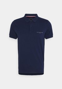 Polo bleu marine à manches courtes avec col, patte à deux boutons et petit logo Tommy Hilfiger sur le côté gauche de la poitrine.