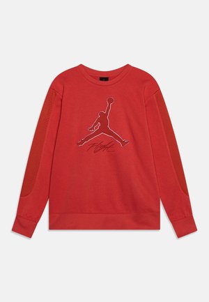 Sweat-shirt rouge à manches longues avec des panneaux en maille sur les manches, présentant une grande silhouette cousue d'un joueur de basketball et le mot "Flight" en dessous.