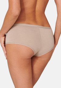 Beige Baumwollhipsterunterwäsche mit glatter Textur und weichem elastischem Bund, ausgestattet mit minimalistischem Design und ohne sichtbare Muster.