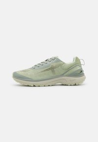 Zielone buty sportowe, które łączą gładkie i teksturowane materiały, mają perforowane akcenty oraz wyściełaną podeszwę z wyraźnym designem obcasa.