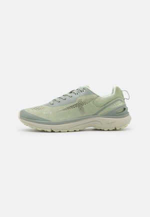 Zielone buty sportowe, które łączą gładkie i teksturowane materiały, mają perforowane akcenty oraz wyściełaną podeszwę z wyraźnym designem obcasa.