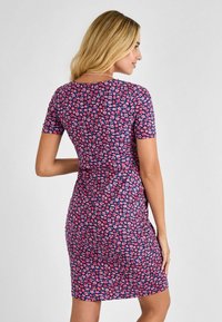 Vestido de manga corta en color navy con un estampado floral en rosa. Diseño ajustado, a la altura de la rodilla, con un escote redondo y una textura de tela suave.