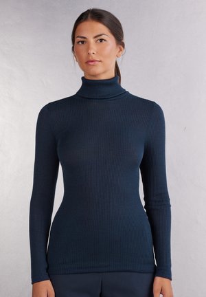 Dunkelblaues, geripptes Rollkragenoberteil mit langen Ärmeln, das eine schmale Silhouette und eine weiche, dehnbare Textur aufweist.