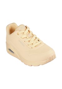 Bež Skechers tenisice s glatkim sintetičkim gornjim dijelom, dizajnom s vezicama, vidljivom zračnom jastučiću, perforiranim detaljima i gumenenim potplatom.