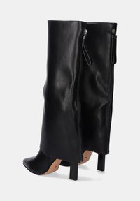 Bota alta de cuero negro con punta afilada, tacón cuadrado y cremalleras laterales dobles. Textura suave con diseño minimalista y acentos.