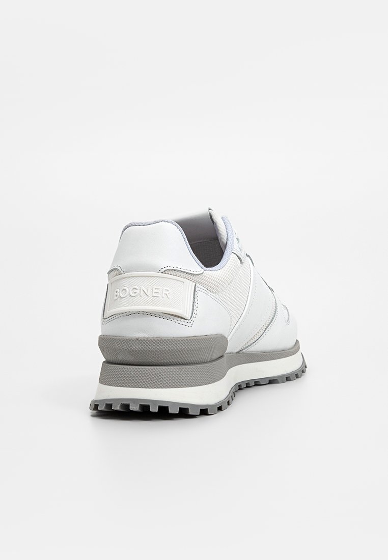 Weiße Sportschuhe mit einem glatten Obermaterial aus Leder, grauen Akzenten, strukturierten Mesh-Einsätzen und einer robusten Gummisohle. "Bognor"-Logo auf der Ferse.