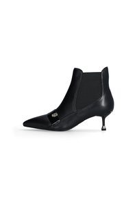 Stivaletto in pelle nera con punta affusolata, pannelli laterali elasticizzati e un piccolo accento metallico sul davanti. Tacco sottile a stiletto.