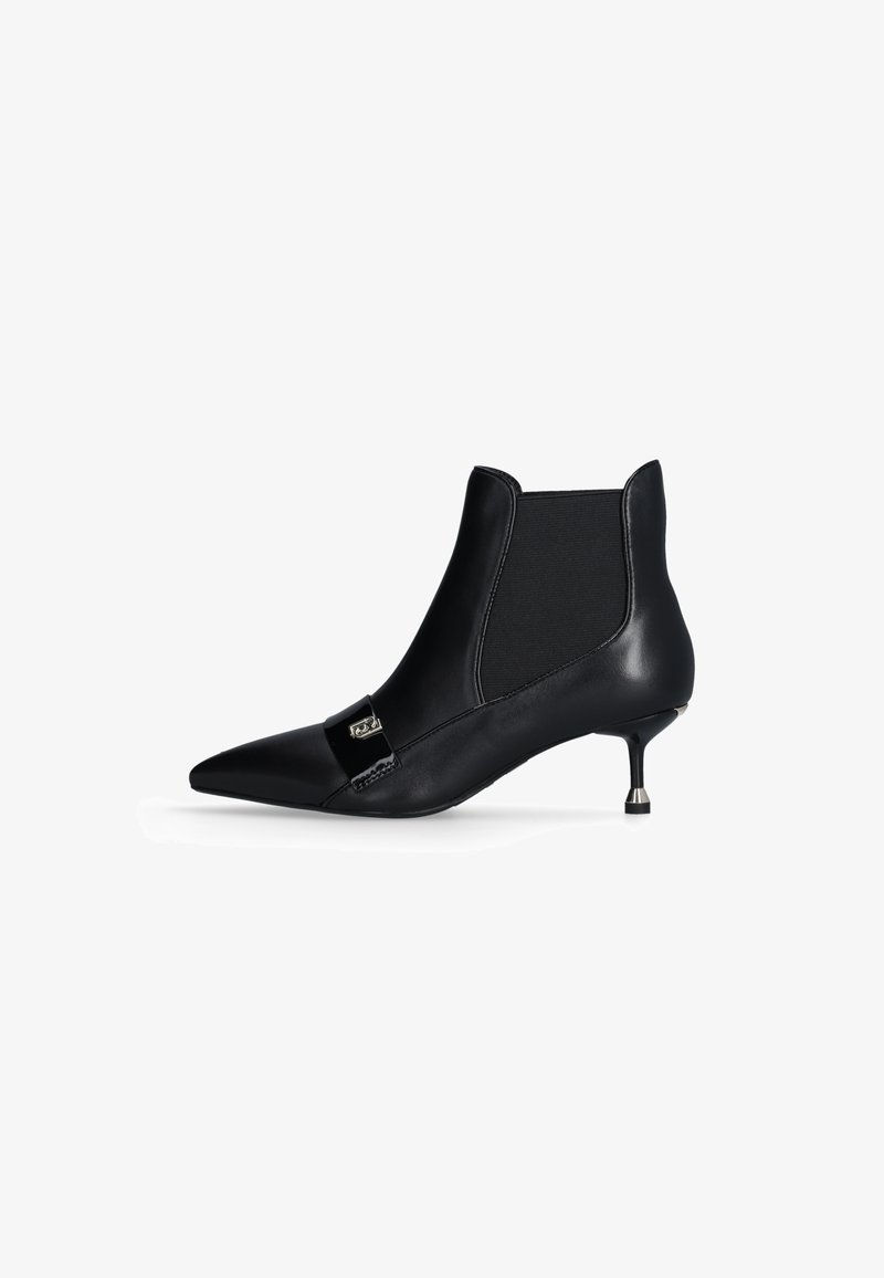 Stivaletto in pelle nera con punta affusolata, pannelli laterali elasticizzati e un piccolo accento metallico sul davanti. Tacco sottile a stiletto.