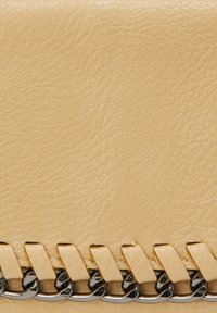 Beige læderpung med en tekstureret overflade, der har et vævet accent og metal kæde detalje langs den nederste kant.