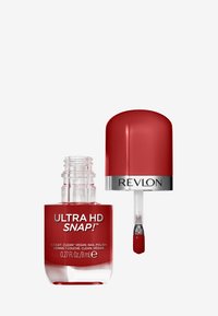 Vernis à ongles végétalien rouge dans un flacon en verre transparent avec un bouchon arrondi. Le pinceau est légèrement surélevé, mettant en valeur la couleur du vernis.