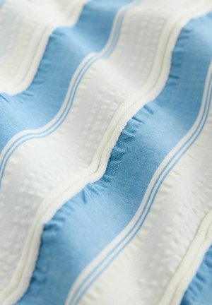 Tissu bleu et blanc avec des rayures ondulées, présentant une surface texturée et des motifs subtils. Le design inclut des lignes fines et une finition lisse.