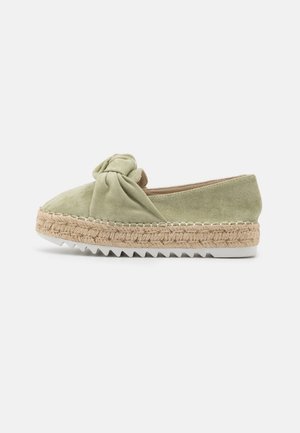 Espadrilla de ante verde claro con diseño delantero anudado, entresuela envuelta en yute y suela de goma con dibujo en zigzag.