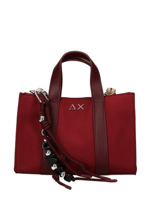 Piccola borsa rossa con manici rosso scuro, logo geometrico argento e nappine decorative con perline nere e argentate sul davanti.