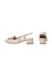 Beige patent leather slingback heels with a square toe, low block heel, and decorative metal buckle on the front.