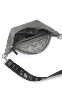 Grau Nylon-Handtasche mit glatter Textur, Reißverschlussfächern und einem abnehmbaren Träger mit fettgedruckten schwarzen Buchstaben. Innenfutter ist ausgekleidet.