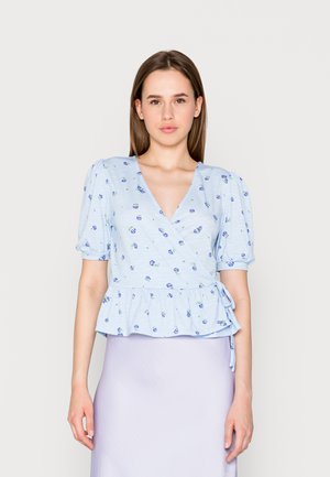 Blusa peplum azul clara em tecido suave, com decote em V, mangas curtas bufantes e padrão floral. Ataca-s ao lado para ajuste personalizado.