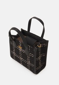 Czarna torba o fakturze z wzorem w kratę, z skórzanymi akcentami, dwoma uchwytami u góry i złotym detalem logo. Wnętrze widoczne, ale częściowo zasłonięte.