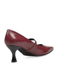 Zapato de charol burdeos con punta afilada, tacón medio negro y una correa en el empeine. Textura suave con un acabado brillante.