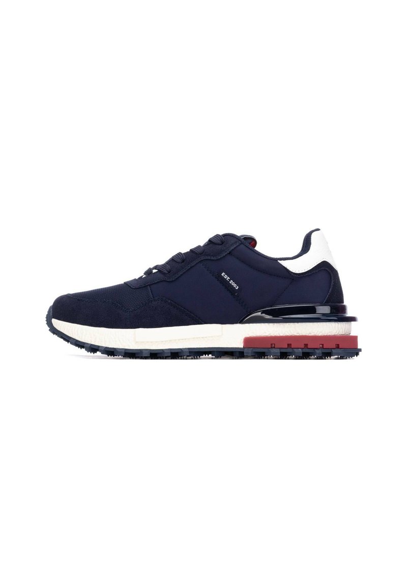 Zapatillas deportivas de marca navy con parte superior de ante y malla, detalles en blanco y rojo, gruesa entresuela blanca y suela exterior de goma negra texturizada. Diseño clásico de cordones.